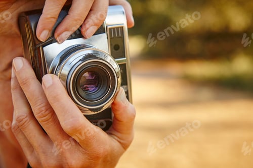 Preview: Woman taking pictures with vintage camera. Travel background.