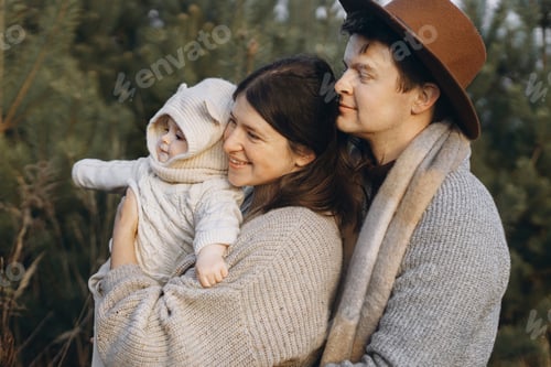 Preview: Happy family hugging with cute baby son in autumn woods in soft evening light. Parenthood