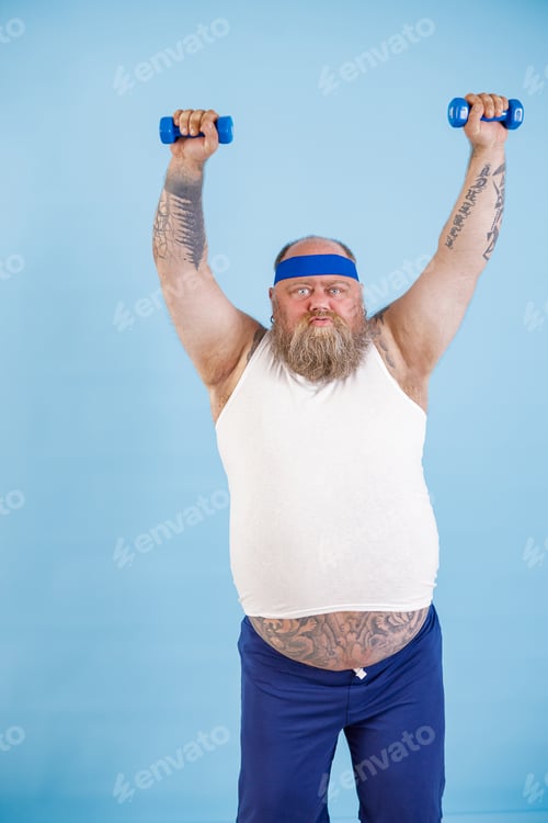 Preview: Fat man does sports exercises with dumbbells trying to loss weight on light blue background