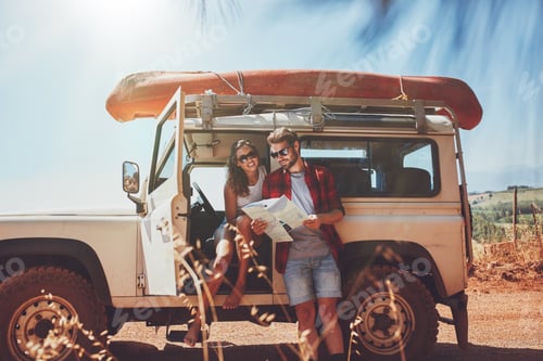 Preview: Young couple using map on a roadtrip