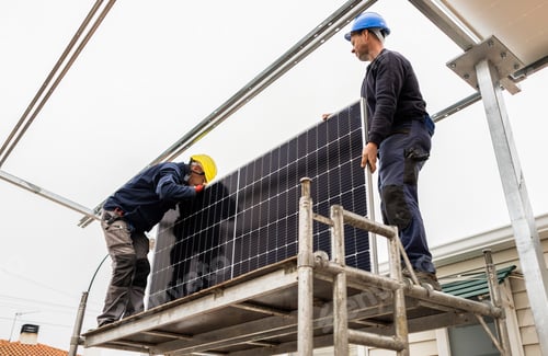Preview: Workers installing solar panel on metal platform using scaffolding