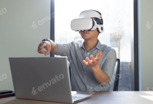 Preview: At office, Using VR headset, asian man interacting with virtual environment while working on laptop