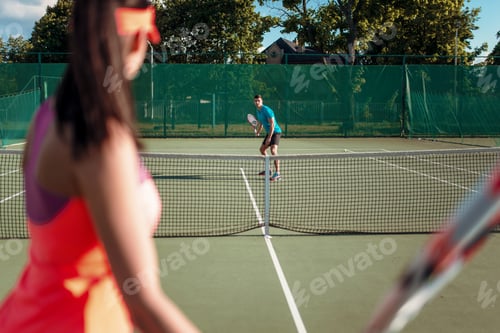 Preview: Couple playing tennis on outdoor court