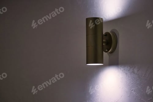 Preview: Stylish modern lamp on white textured vintage wall. Glowing chrome led lamp for design interior