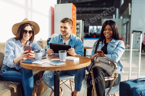Preview: Three tourists with phones waiting in airport