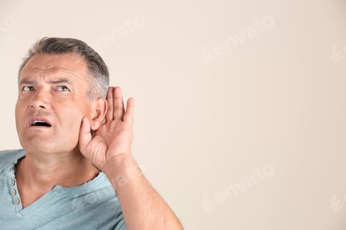 Vista previa: Mature man with hearing problem on light background. Space for text