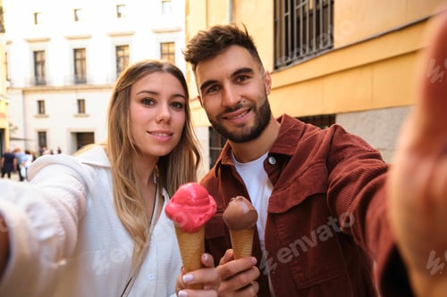 Preview: Young Caucasian couple taking a selfie while eating an ice cream.