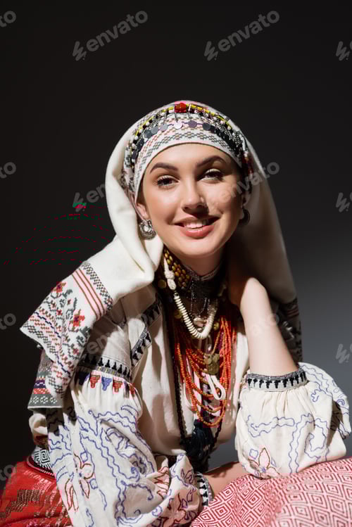 Preview: portrait of happy young ukrainian woman in traditional clothing with ornament and red beads on black