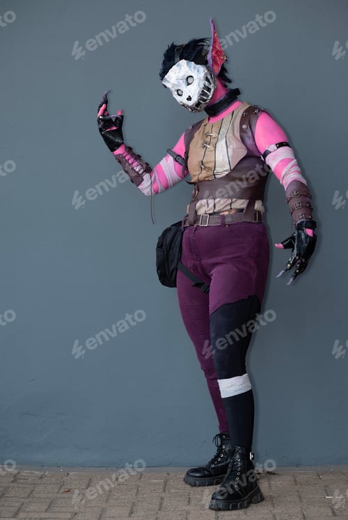 Preview: Female cosplayer dressed as a pink monster with a skull mask