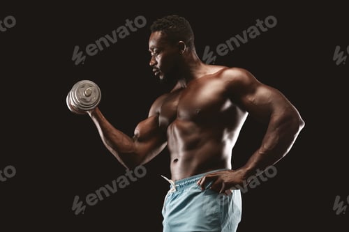 Side view of african bodybuilder doing single arm dumbbell curl