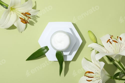Preview: Jar with cream and lilies on green background, top view