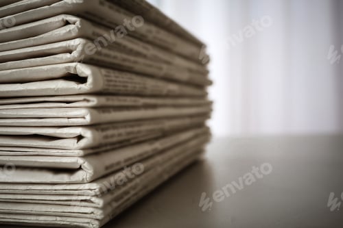 Preview: Stack of newspapers on grey table, space for design. Journalist's work