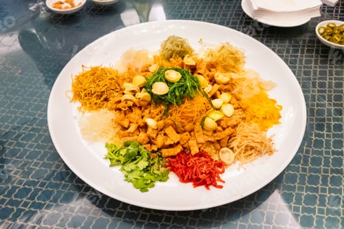 Preview: Serving of auspicious yusheng or yee sang with abalone in restaurant during Chinese New Year