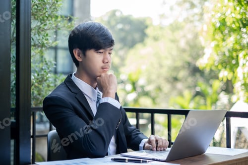 Preview: Young Asian businessman financial market analyst sits at their desks and calculate financial graphs
