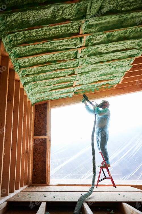 Preview: Worker spraying polyurethane foam for insulating wooden frame house.