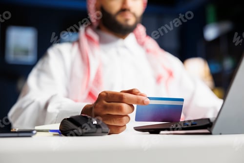 Preview: Arab man online shopping with laptop