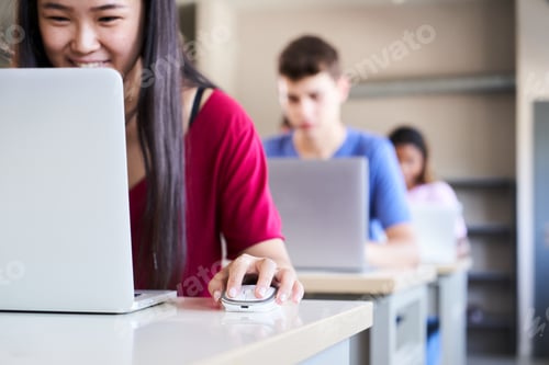 Preview: In a high school classroom a group of cheerful students study using a laptop computer. Happy young.
