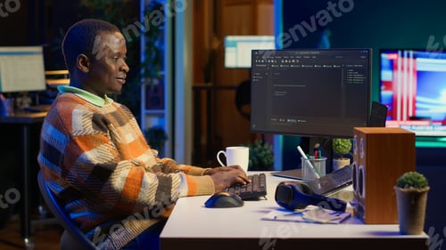 Preview: African american self employed developer in home office coding on his computer