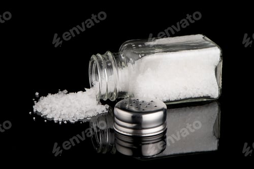 Salt Shaker and Salt Crystals on Black Surface