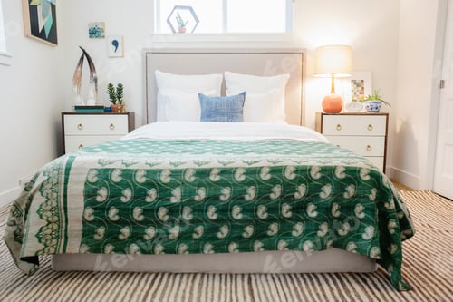 Preview: A bedroom in an apartment with a double bed and beside cabinets, and a green fabric patterned
