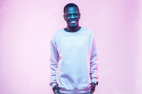 Preview: Young african american man standing with hands in pockets, wearing blank white swearshirt
