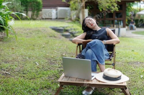 Preview: Young woman sleeping while working outdoors in garden