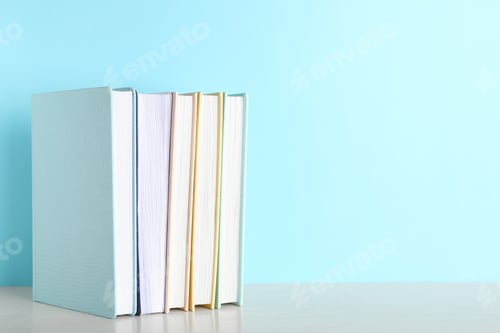 Preview: Hardcover books on table against color background, space for text