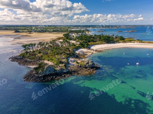 Preview: Aerial view of Perharidy peninsula from drone, with lush palms, on a sunny day with blue sky