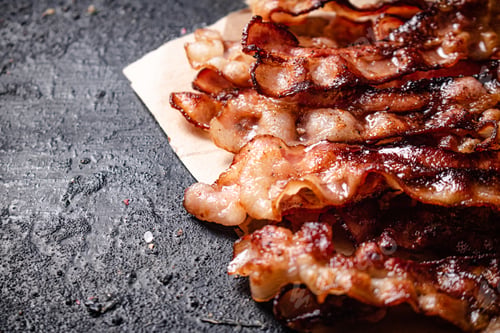 Preview: Pieces of fried bacon on paper.