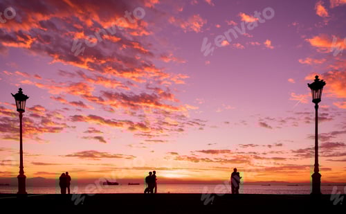 Preview: Silhouettes of people enjoying a walk during sunset