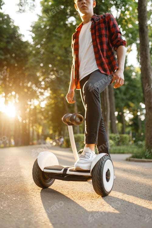 Preview: Young male person riding on gyroboard in park
