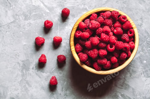 Preview: raspberries in wood bowl on gray table, vintage