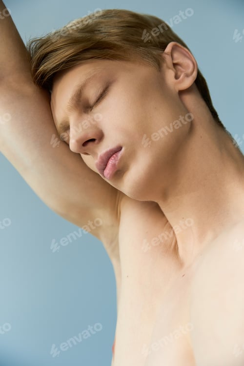 Preview: Young man embraces modern masculinity with captivating charm in serene setting