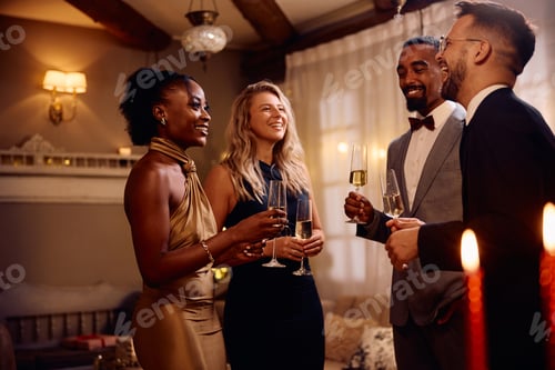 Preview: Multiracial group of cheerful friends talking and drinking champagne at Christmas.