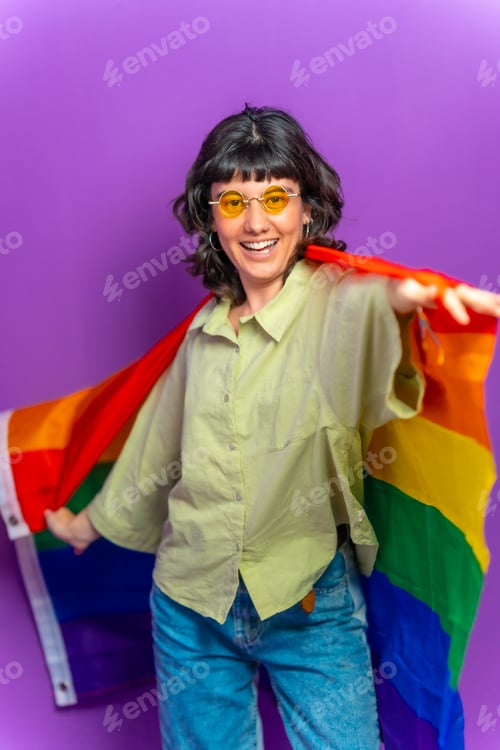Preview: Non binary latin woman dancing wrapped with lgbt rainbow flag