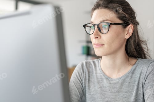 Preview: Woman with glasses working on a computer