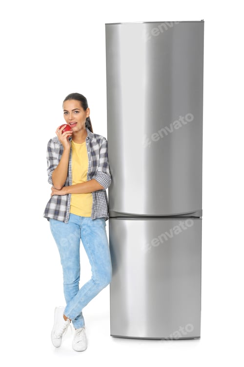 Preview: Young woman eating apple near closed refrigerator on white background