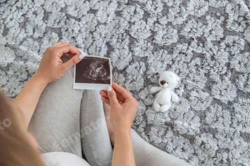 Preview: A pregnant woman collects baby things. Selective focus.