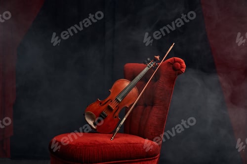 Preview: Violin in retro style and bow on the chair, nobody