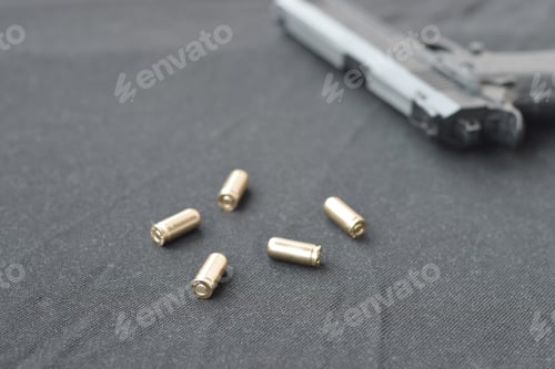 Preview: 9mm bullets and pistol lie on a black fabric. A set shooting ran
