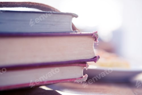 Preview: Stack of books on table in brightly lit office