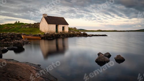 Preview: Traditional stone cottage fisherman hut lakeside of Connemara national park Ireland at sunrise