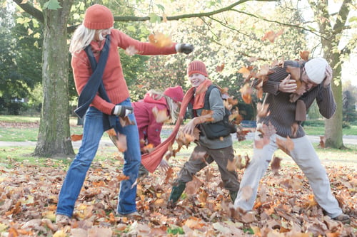 Preview: Family fooling around in park, throwing autumn leaves