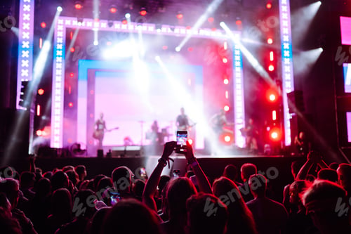Preview: Hand with a phone records live music festival. People taking photographs with smart phone.