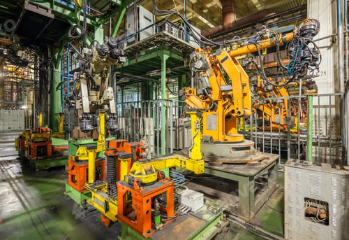 Preview: Bankrupt and abandoned automobile plant. Yellow robots welding cars in a production line.