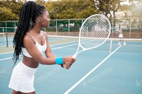 Preview: Young athlete waiting to serve during a tennis match. Focused african american tennis player during