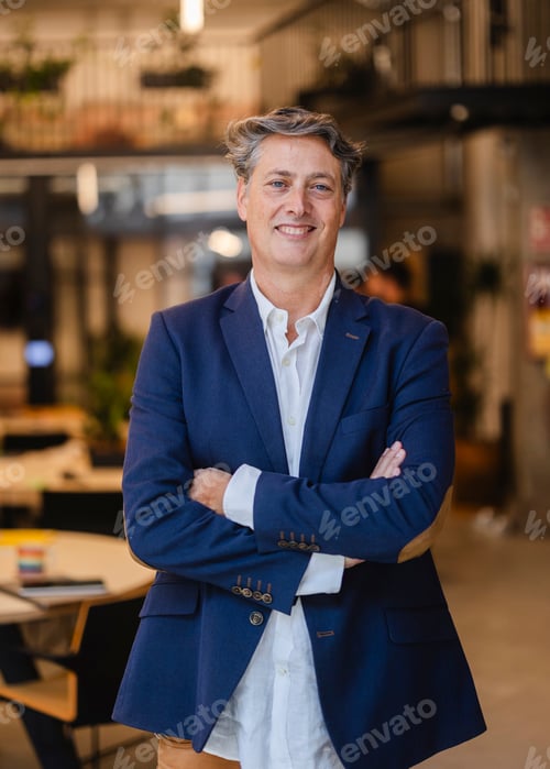 Preview: Portrait of smiling senior manager with crossed arms in modern office