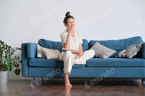Preview: Woman Relaxing on Sofa with Notebook at Home
