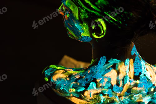 Preview: back view of model with colorful neon paints on body on black background