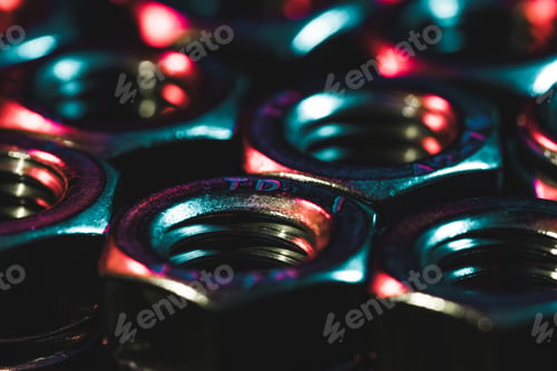 Preview: Closeup shot of small metal screw nuts in a dark atmosphere